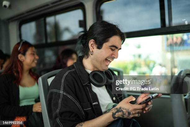 joven usando un teléfono móvil en un autobús - man riding bus fotografías e imágenes de stock