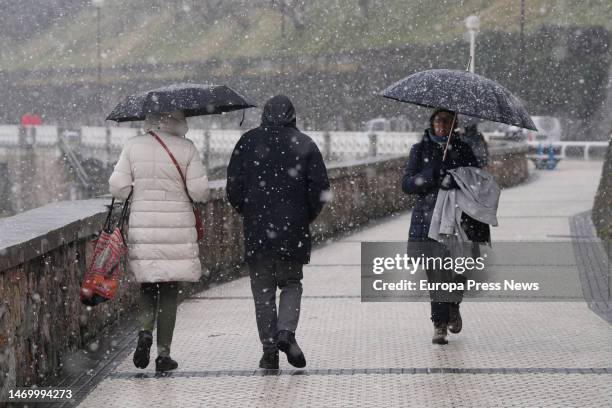 Several people walk along the promenade of Ondarreta beach as it snows, on 27 February, 2023 in San Sebastian, Gipuzkoa, Basque Country, Spain....