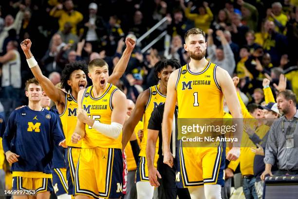 Kobe Bufkin and Joey Baker of the Michigan Wolverines react after Hunter Dickinson of the Michigan Wolverines made a shot that forced the game into...