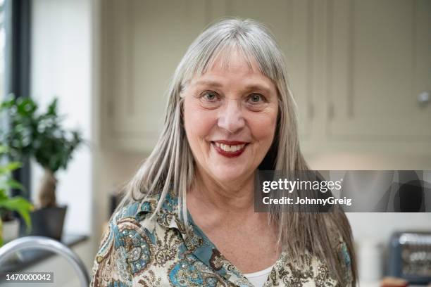 portrait of smiling senior woman in home interior - women with long hair stock pictures, royalty-free photos & images