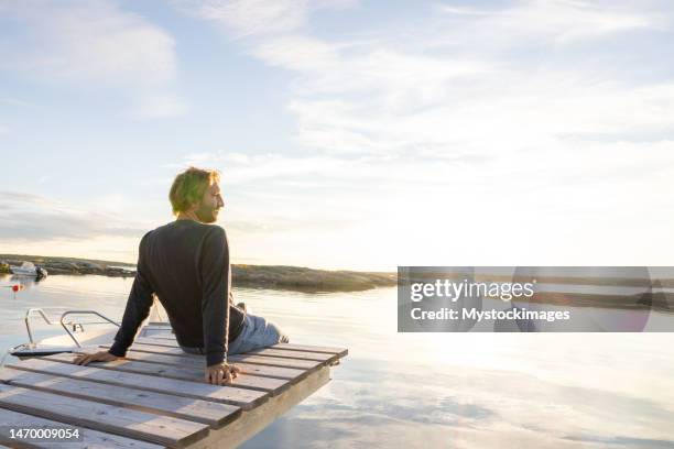 l’homme contemple la nature et se reflète sur le lac au coucher du soleil - ponton photos et images de collection