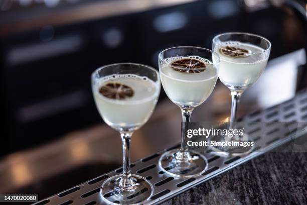 gimlet or daiqiri cocktails in three glasses on bar counter. - tequila tasting stock pictures, royalty-free photos & images