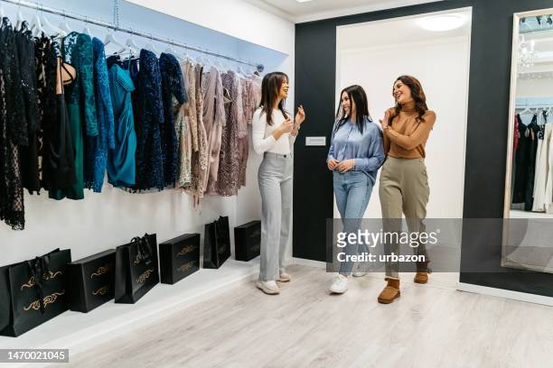 two female friends arriving in the clothing store - entering shop stock pictures, royalty-free photos & images