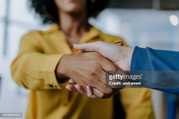 two businesswomen shaking hands - handshake closeup stock pictures, royalty-free photos & images