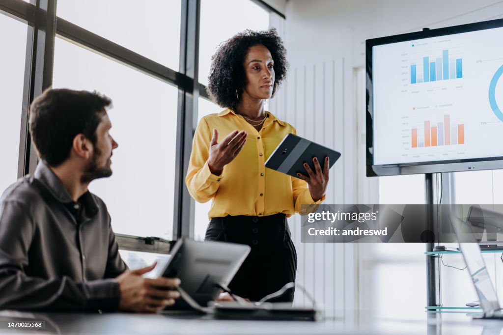 Business woman presenting financial result holding digital tablet