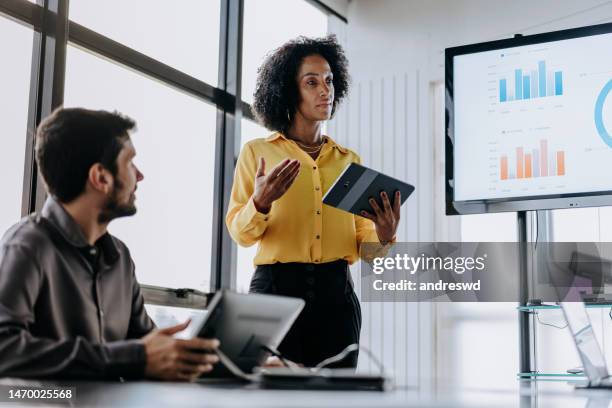 business woman presenting financial result holding digital tablet - board room meeting stock pictures, royalty-free photos & images