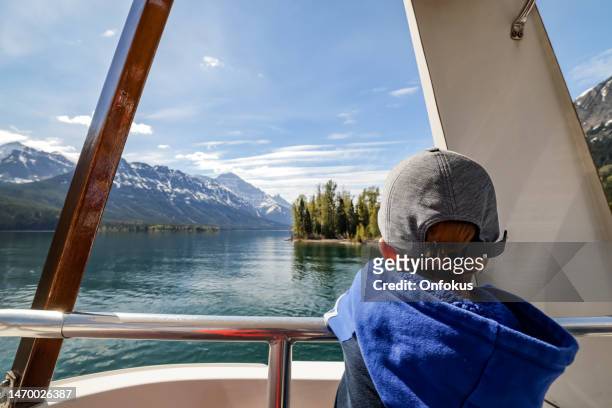 young boy on boat tour auf dem waterton lake im waterton lakes national park, alberta, kanada - waterton lakes national park stock-fotos und bilder
