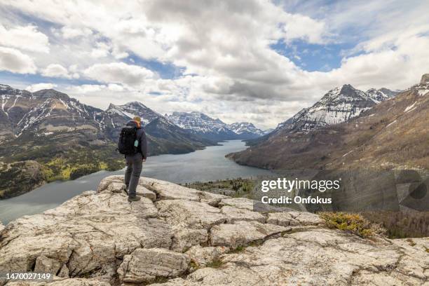 young man looking at the view while hiking at bear's hump trail in waterton lakes national park, alberta, canada - waterton lakes national park stockfoto's en -beelden