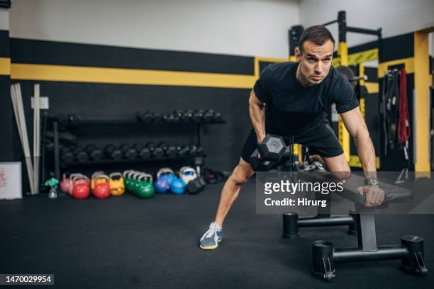 weightlifting practice with dumbbell - workout bench stock pictures, royalty-free photos & images
