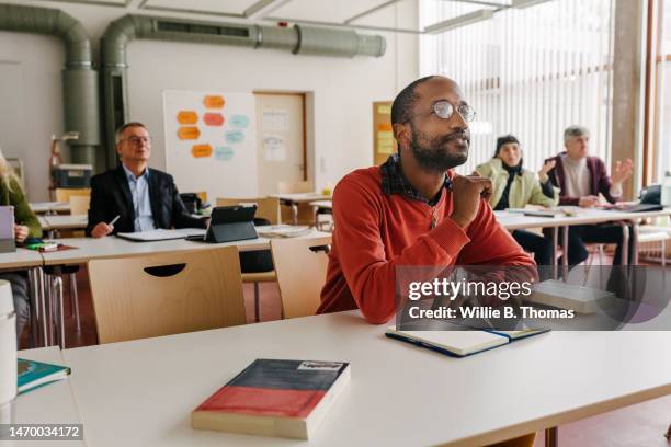 mature students listening during classroom - community college stockfoto's en -beelden