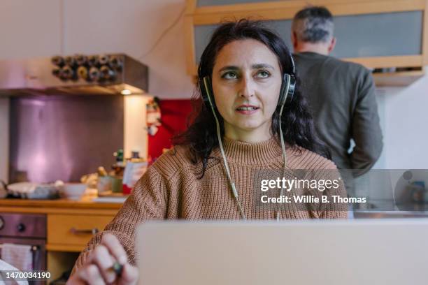 mature student studying at home in her kitchen - working wife stock pictures, royalty-free photos & images