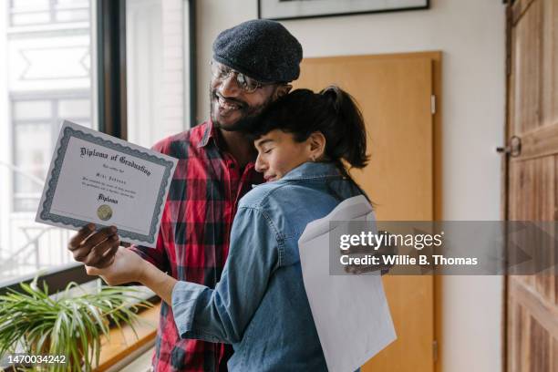 mature student hugging wife after receiving diploma - receiving diploma stock pictures, royalty-free photos & images