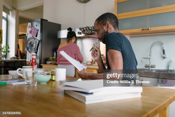 mature student working in his kitchen at home - sich verschönern stock-fotos und bilder