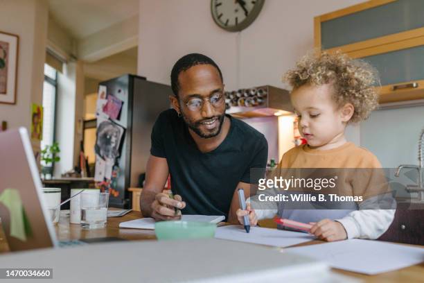 father playing with young son while studying at home - boy in briefs photos et images de collection