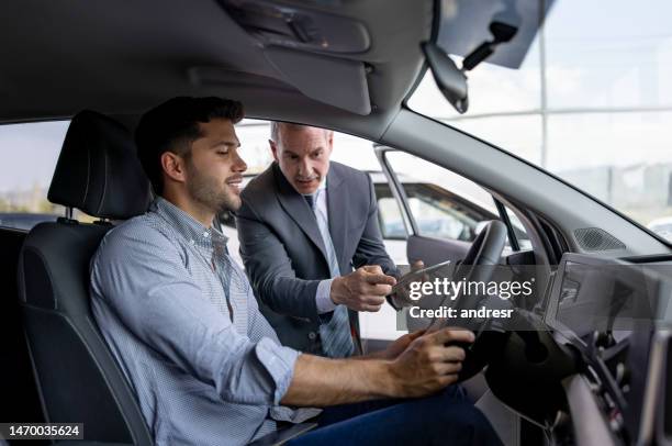 salesman showing the interior of a car to a man interested in buying a vehicle - customer test drive stock pictures, royalty-free photos & images