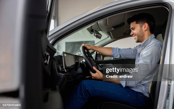 happy man test driving a car while shopping at the dealership - customer test drive stock pictures, royalty-free photos & images