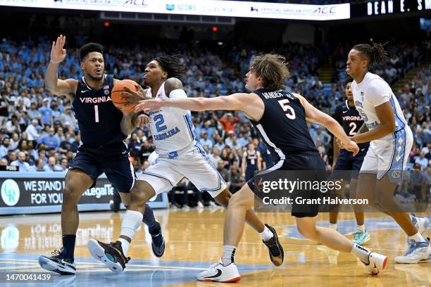 Caleb Love of the North Carolina Tar Heels drives between Jayden Gardner and Ben Vander Plas of the Virginia Cavaliers during their game at the Dean...