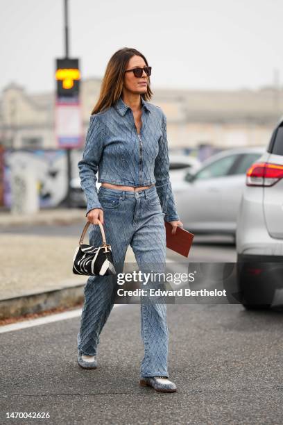 Guest wears black sunglasses, a blue faded denim embroidered checkered pattern zipper jacket, matching blue faded denim embroidered checkered pattern...