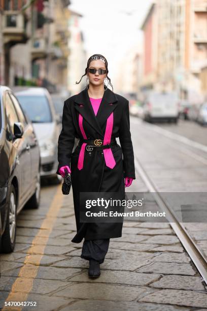 Guest wears silver hair clips, black sunglasses, a neon pink t-shirt, a neon pink silk tie, a black long oversized coat, black shiny leather with...