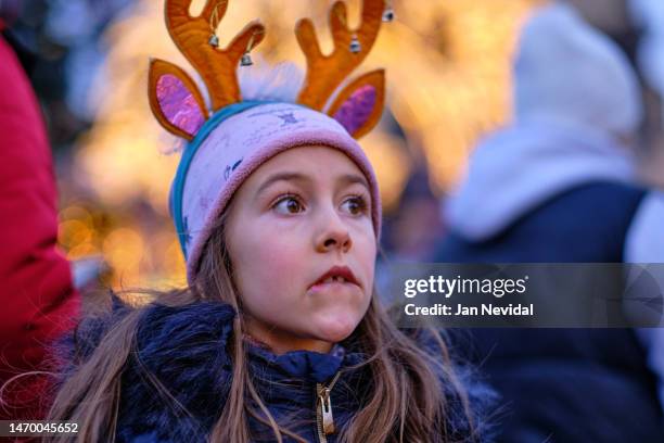 portrait of young girl with moose antlers headband standing at chirstmas market - white moose stock pictures, royalty-free photos & images