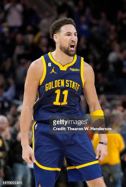 Klay Thompson of the Golden State Warriors reacts after making a three-point shot against the Minnesota Timberwolves during the fourth quarter at...