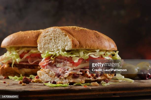 muffuletta, italian sandwich with olive , roasted peppers and artichoke spread - submarine sandwich imagens e fotografias de stock