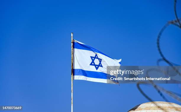 israel national flag against perfect clear blue sky in old city of jerusalem, israel - bandera de israel fotografías e imágenes de stock