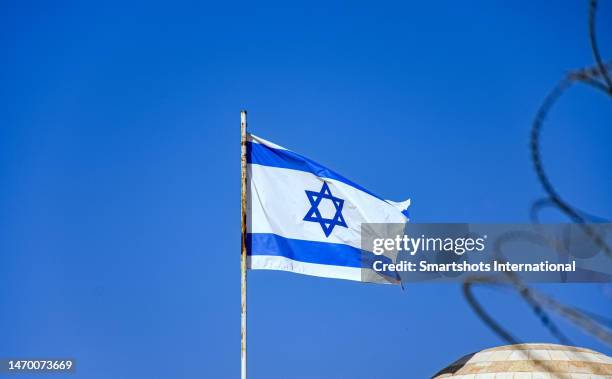 israel national flag against perfect clear blue sky in old city of jerusalem, israel - israeli flag stockfoto's en -beelden
