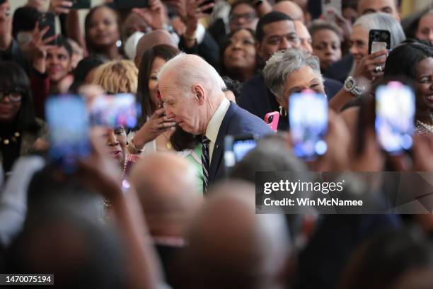 President Joe Biden makes his way through the audience during an event in the East Room of the White House marking Black History Month February 27,...