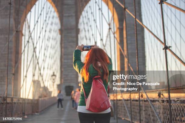 woman photographing the brooklyn bridge in new york city, usa - the bigger picture stock photos et images de collection