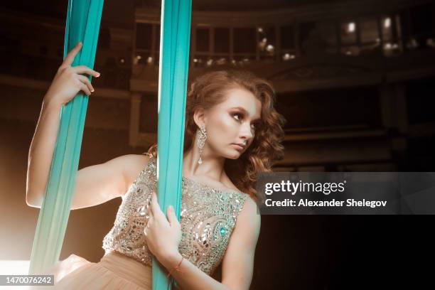 female portrait of woman who working in circus as performer and acrobatic artist. girl wear beautiful dress indoors. - stunt performer bildbanksfoton och bilder