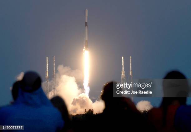 People watch as a SpaceX Falcon 9 rocket lifts off from launch pad 40 at Cape Canaveral Space Force Station on February 27, 2023 in Cape Canaveral,...