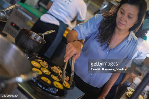 vietnamese restaurant owner cooking mini pancake banh khot - hot vietnamese women stock pictures, royalty-free photos & images