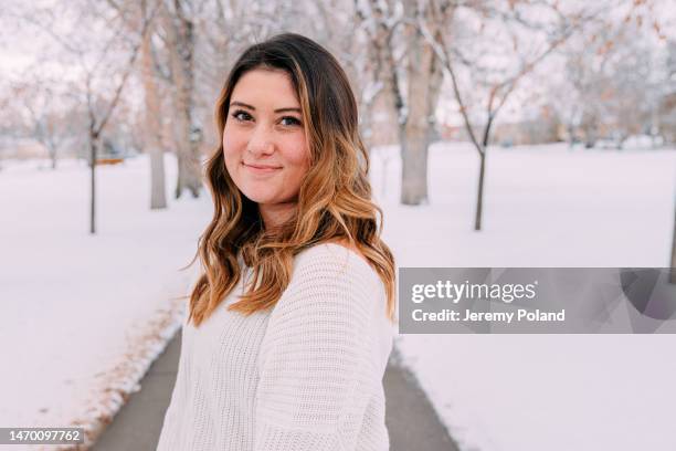 cute close-up portrait of a cheerful university student standing wearing a sweater looking at camera on campus on a snowy day in colorado with copy space - colorado state university stock pictures, royalty-free photos & images