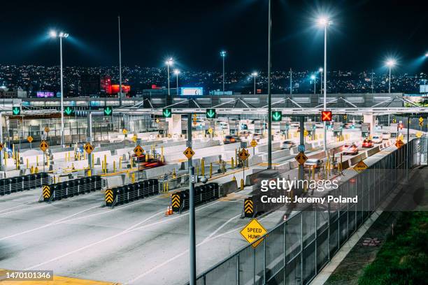 long shutter of cars crossing the us-mexico border at tijuana/san ysidro into san diego, california, us on a quiet night - rijksgrens stockfoto's en -beelden