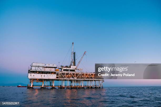 oil rig at dusk off the coast of huntington beach, california - organization-of-the-petroleum-exporting-countries stock pictures, royalty-free photos & images