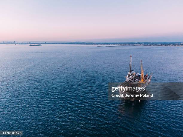 an elevated view of an offshore oil drilling rig at dusk near huntington beach with copy space - oil drill stock pictures, royalty-free photos & images