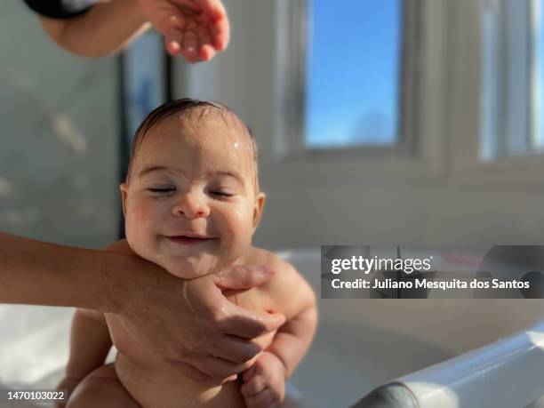 baby in der badewanne beim baden - mother and baby taking a bath stock-fotos und bilder