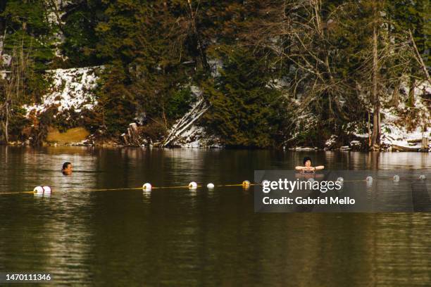 people swimming at buntzen lake during winter - buntzen lake stock-fotos und bilder