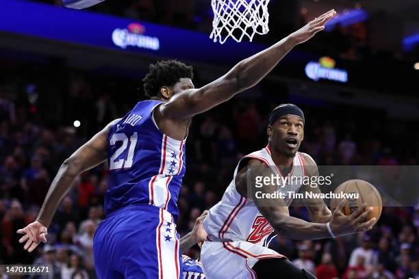 Jimmy Butler of the Miami Heat shoots a lay up past Joel Embiid of the Philadelphia 76ers during the fourth quarter at Wells Fargo Center on February...