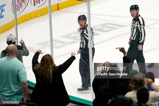 Fans gesture at referees as they skate off the ice after the game between the Dallas Stars and the Vancouver Canucks at American Airlines Center on...