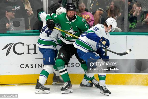 Jamie Benn of the Dallas Stars competes for the puck against Kyle Burroughs of the Vancouver Canucks and Nils Aman \d3p at American Airlines Center...