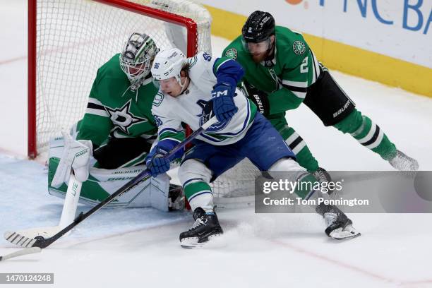 Andrei Kuzmenko of the Vancouver Canucks shoots the puck against Jake Oettinger of the Dallas Stars as Jani Hakanpää of the Dallas Stars defends in...