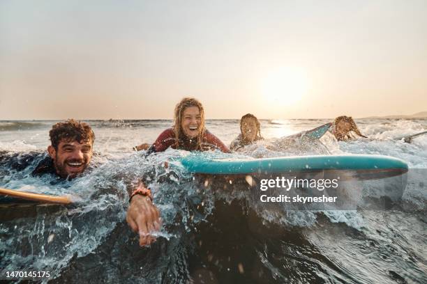 surfing in sea at sunset! - surfer wetsuit stock pictures, royalty-free photos & images