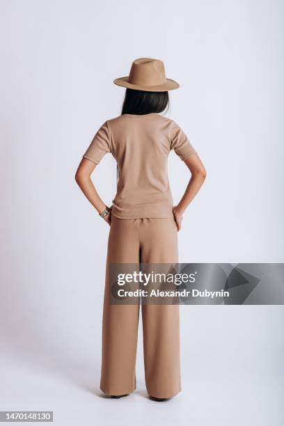 back view of a female model posing in a new collection of clothes on a white background - woman standing imagens e fotografias de stock