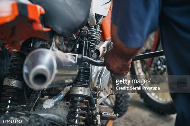man repairing enduro motorcycle - motocross gear stock pictures, royalty-free photos & images