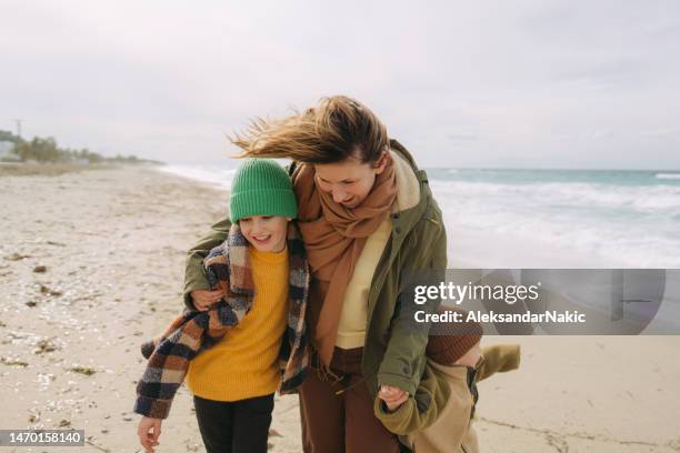 walk with mom down the windy beach - beach winter stock pictures, royalty-free photos & images