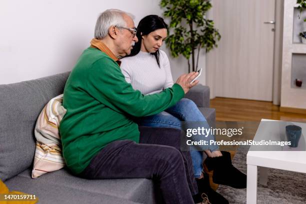 home caregiver teach senior man to use tablet - things that go together imagens e fotografias de stock