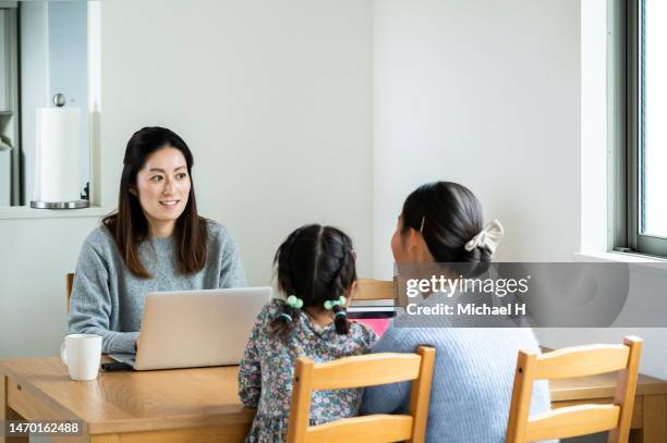 mother working in the living room with her children - multitasking student stock pictures, royalty-free photos & images