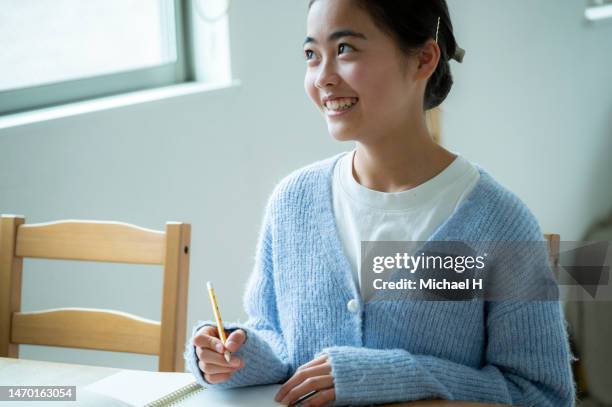 a girl writing homework at table - escritura japonesa imagens e fotografias de stock